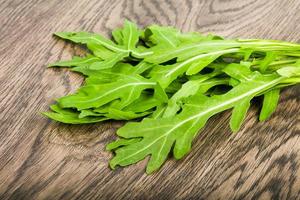 feuilles de roquette sur fond de bois photo