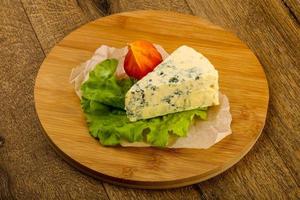 Fromage bleu sur planche de bois et fond de bois photo