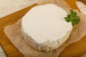 Fromage camembert sur planche de bois et fond de bois photo