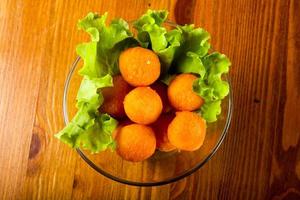 boulettes de fromage dans un bol sur fond de bois photo