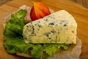 Fromage bleu sur planche de bois et fond de bois photo