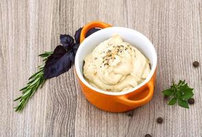 Houmous dans un bol sur fond de bois photo