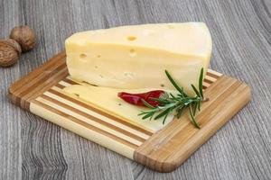 Fromage jaune sur planche de bois et fond de bois photo