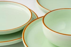 un ensemble de vaisselle en céramique vert pastel aux contours orange photo
