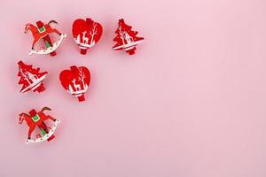 décorations de noël en bois rouge et blanc sur fond rose, vue de dessus. photo