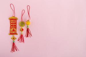 décorations traditionnelles vietnamiennes et chinoises du nouvel an couleurs rouges et dorées sur fond rose, vue de dessus. photo