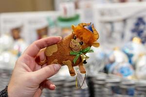 moscou, russie, 2020 - jouets exposés au marché de noël. décoration festive pour sapin de noël. main féminine tenant le taureau - symbole de l'année 2021. photo