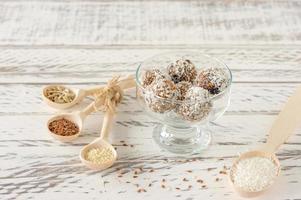 bouchées de boules d'énergie bio saines avec noix, cacao, noix de coco et miel - collations ou aliments crus végétariens végétaliens. photo