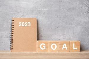 Calendrier 2023 avec bloc de but sur table en bois. bonne année, motivation, résolution, liste de choses à faire, démarrage, concept de stratégie et de plan photo