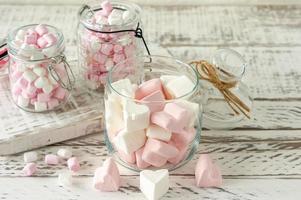 guimauves blanches et roses pour rôtir et chocolat chaud dans un bol, gros plan. concept de fond de nourriture d'hiver. photo