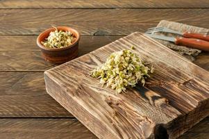 aliments macrobiotiques. haricots mungo germés prêts à manger sur une planche de service en bois. style rustique photo