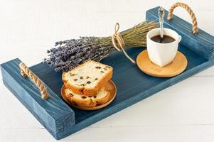 tranches de quatre-quarts aux raisins secs et une tasse de café servie sur un plateau. petit déjeuner savoureux du matin photo