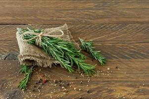 romarin lié sur une planche de bois avec des graines sèches photo