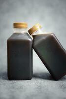 deux bouteilles de boisson froide au café noir, boisson rafraîchissante pour le petit-déjeuner frais photo