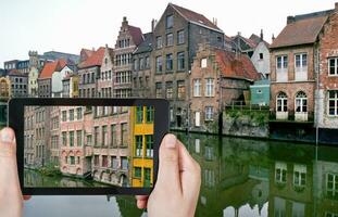 touriste prenant une photo de vieilles maisons à gand