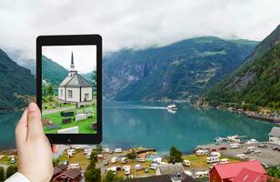 touriste prenant une photo du village de geiranger