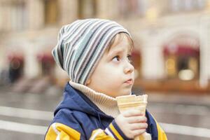 portrait d'un garçon mignon dans le parc au printemps. un garçon avec un chapeau dans la rue. marcher, jouer et s'amuser. émotions, joie. portrait d'enfant. photo