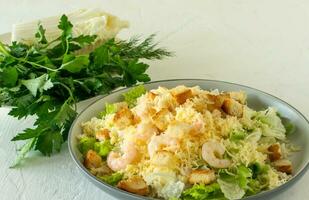 Salade césar de crevettes maison avec parmesa, sauce et croûtons sur fond blanc photo