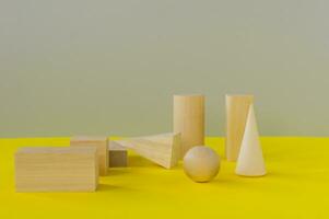 formes géométriques en bois sur fond jaune. apprentissage préscolaire