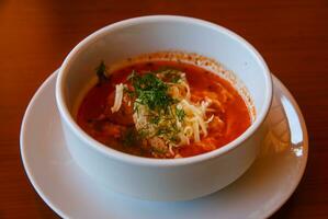 Soupe aux tomates dans un bol sur fond de bois photo