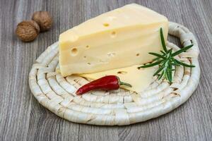 Fromage jaune sur planche de bois et fond de bois photo