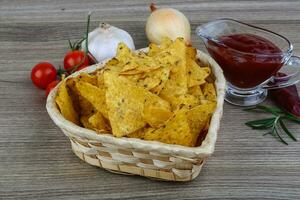 nachos dans un panier sur fond de bois photo