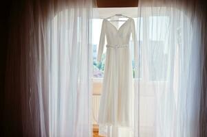 robe de mariée suspendue au plafond. jour de la mariée. photo