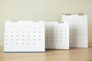 page de calendrier gros plan sur une table en bois avec fond de mur blanc photo