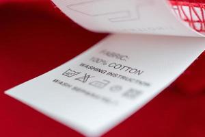 Entretien du linge blanc instructions de lavage étiquette de vêtements sur une chemise en coton rouge photo