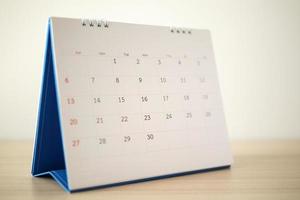 page de calendrier gros plan sur une table en bois avec fond de mur blanc photo