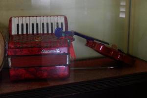 istana maimun, medan, indonésie - 16 novembre 2021, un petit violon et un accordéon de couleur rouge derrière une vitrine photo