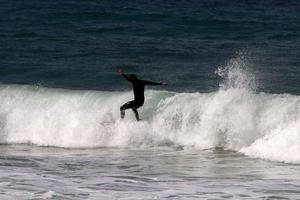 surf sur de hautes vagues sur la mer méditerranée dans le nord d'israël. photo