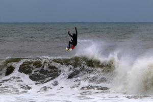 surf sur de hautes vagues sur la mer méditerranée dans le nord d'israël. photo