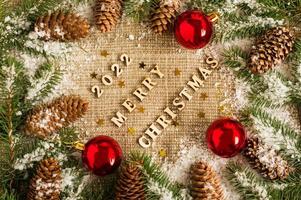 fond de noël et du nouvel an sur toile de jute avec les chiffres de l'année à venir, branches d'épinette, cônes et jouets, boules rouges. vue de dessus. photo