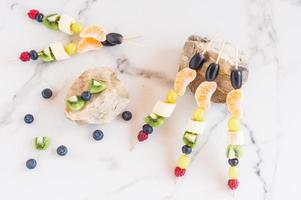 assortiment de canapés de fruits sur pierres, fond de marbre blanc. vitamines végétales. photo