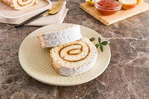 deux morceaux de pommes tendres roulées dans du sucre en poudre sur une assiette sur une table en marbre. délicieux dessert, collation. photo