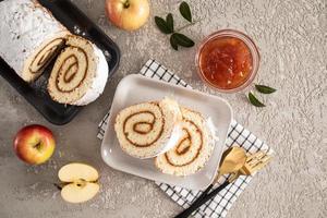 rouleau de génoise tendre fraîchement cuit avec de la confiture de pomme pour demain. dessert délicieux. gâteaux faits maison. photo