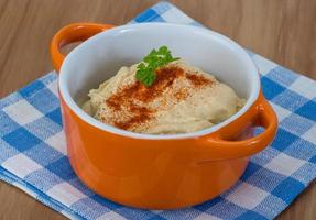 Houmous dans un bol sur fond de bois photo