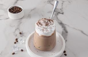 un grand verre de café au lait ou de cappuccino avec du lait et de la crème fouettée ou de la crème glacée. délicieux dessert d'été par temps chaud. photo