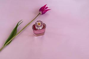 un flacon de parfum en cristal avec une fleur délicate. vue de dessus. fond serein. une copie de l'espace. présentation des arômes. photo