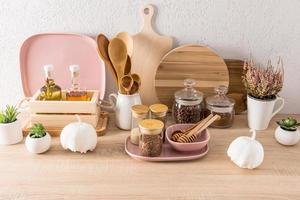 fond intérieur de la cuisine. comptoir moderne avec divers ustensiles de cuisine, canettes et récipients pour le stockage des aliments. décor de citrouille blanche. photo