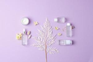 composition cosmétique avec des produits cosmétiques de soins de la peau et des fleurs sur fond rose. mise à plat, espace de copie photo