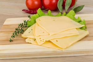 tranches de cheddar sur planche de bois et fond blanc photo