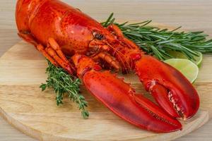 Homard bouilli sur planche de bois et fond blanc photo