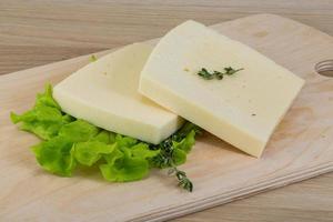 Cheddar jaune sur planche de bois et fond blanc photo