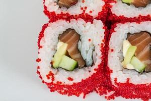 sushi maki épicé tobiko - rouleau chaud avec divers types d'œufs de poisson volant à l'extérieur. saumon, avocat et laitue verte à l'intérieur photo