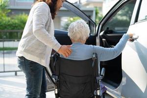 Une patiente asiatique âgée ou âgée, assise sur un fauteuil roulant, se prépare à aller à sa voiture, concept médical solide et sain. photo