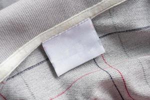 étiquette de vêtements de soin du linge sur la texture du tissu photo