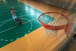 Voir la photo d'un vétéran de la guerre jouant au basket-ball dans une arène sportive moderne. le concept de sport pour les personnes handicapées