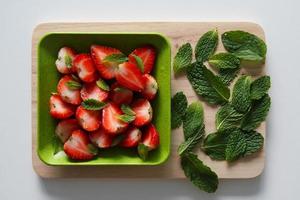 fraise fraîche avec des feuilles de menthe sur fond blanc. photo
